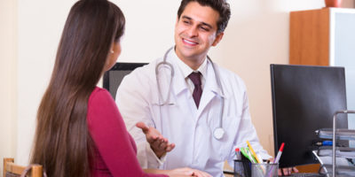 Patient and therapeutist at desk in clinic.